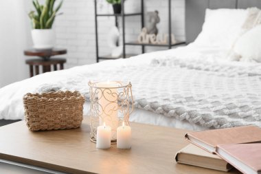 Yatak odasının içinde kitap ve mum yakma tezgahı. Yakın çekim.