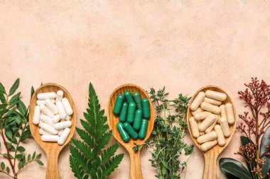 Renkli arka planda farklı haplar ve taze bitkiler içeren kompozisyon, yakın plan