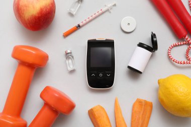 Kalemli glukometre, insülin, hafif arka planda yiyecek ve spor ekipmanları. Diyabet kavramı