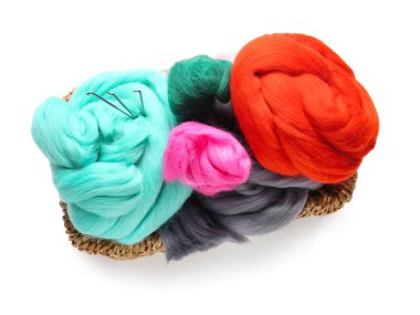 Beyaz arka planda farklı yün ve iğneler var.