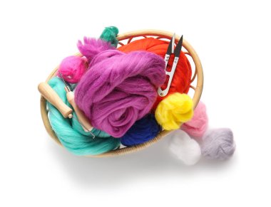 Beyaz arka planda farklı yün, iplik kesici ve iğneler var.