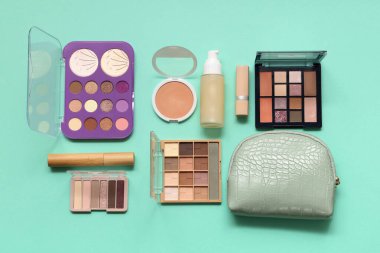 Yeşil arka planda kozmetik çanta ve makyaj ürünleri
