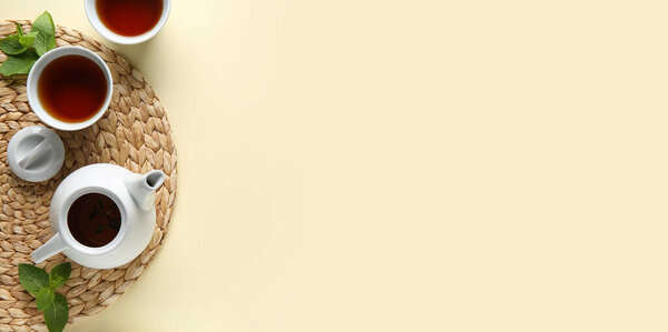 Composition with tea pot and cups of beverage on beige background with space for text, top view