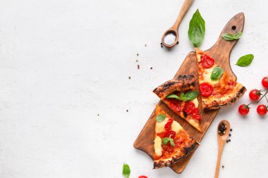 Tahta tahta tahta tahta tahta, lezzetli pizzalar Margarita ve beyaz arka planda taze domatesler.