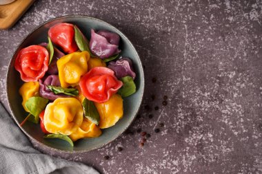 Bir kase kaynamış renkli hamur köftesi, ıspanaklı ve biberli.