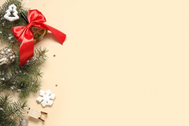 Noel çanı, köknar dalları ve bej arka planda güzel süslemeler.