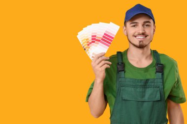 Sarı arka planda renk paletleri olan genç bir ressam