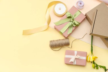 Paket kağıtlı hediye kutuları ve sarı arka planda güzel bir çiçek. Uluslararası Kadınlar Günü