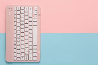 Pembe arkaplanda pembe bilgisayar klavyesi. Üst görünüm