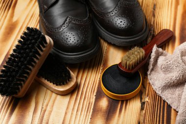 Ahşap arka planda fırçalar, parlak ayakkabılar, kumaş ve ayakkabı cilası.