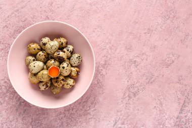 Pembe arka planda taze bıldırcın yumurtalı kase.