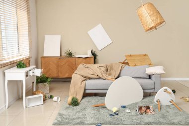 Kanepe, masa ve bitkilerle dolu dağınık bir oturma odası.