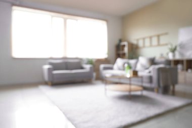 Oturma odasının bulanık manzarası, kanepeler ve masa.