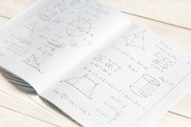 Beyaz ahşap zemin üzerine el yazısıyla yazılmış matematik formülleri içeren metin