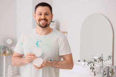 Banyoda diş pudrası olan genç bir adam.