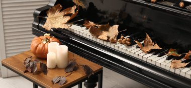 Odada sonbahar süslemeleri olan büyük piyano.