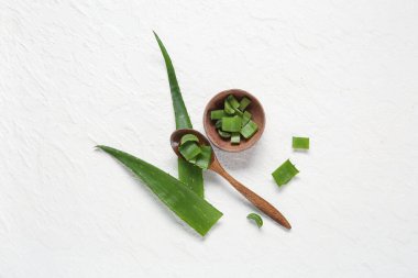Beyaz arka planda kesilmiş aloe yapraklı kaşık ve kase