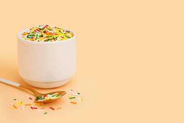 Renkli süslemeli kase ve bej arka planda kaşık.