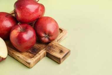 Yeşil arka planda taze kırmızı elmalı ahşap tahta.