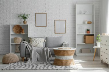 Oturma odasında ekoseli, yastıklı ve kahve masalı rahat bir kanepe.