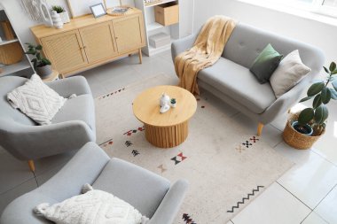 Rahat bir kanepe, koltuklar ve oturma odasındaki dekorlu kahve masası.