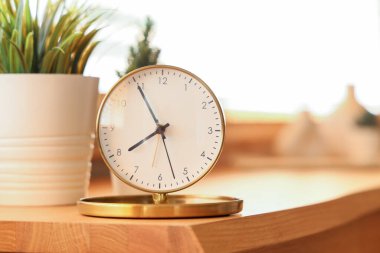 Altın çalar saat ve masadaki ev bitkileri. Yakın çekim.