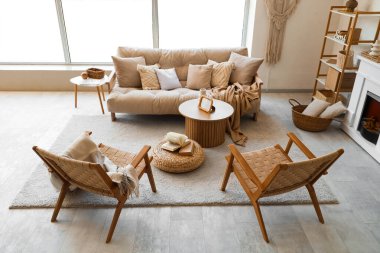 Oturma odası, kanepe, rattan koltuklar ve kahve masası.