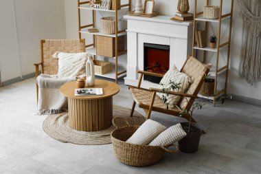 Koltuklar, kahve masası ve şömine oturma odasında.