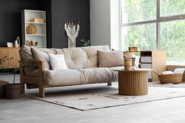 Oturma odasının iç tarafında dizüstü bilgisayarı olan rahat bir kanepe ve kahve masası.