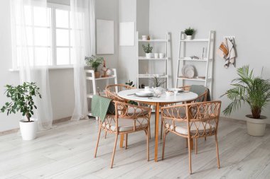 Hasır sandalyeli yemek masası ve şık mutfak odasındaki raf üniteleri.