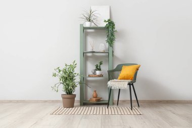 Salondaki beyaz duvarın yanındaki raf ve sandalye.