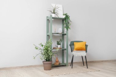 Salondaki beyaz duvarın yanındaki raf ve sandalye.