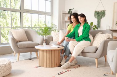 Evde koltukta oturan genç lezbiyen çift