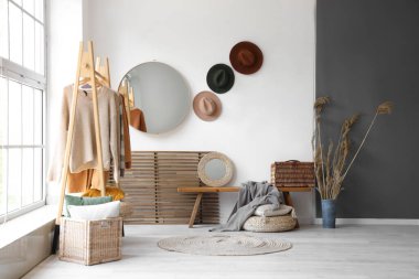 Odanın içinde ahşap bank, elbise askısı ve aynalar var.