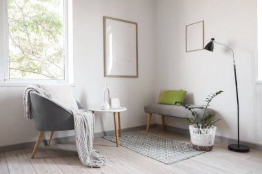 Oturma odasının içinde yumuşak bank, koltuk ve masa var.