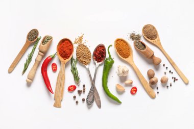 Gri arka planda aromatik baharatlı farklı kaşıklar ve kepçeler