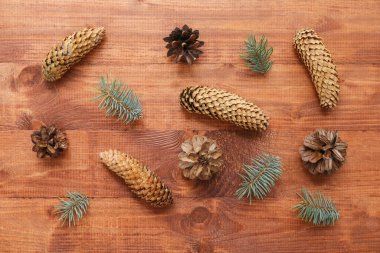 Noel kompozisyonu köknar ağacı dalları ve tahta arka planda koniler. Üst görünüm