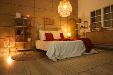 Karanlık yatak odasının içinde rahat bir yatak odası ve parlak lambalar var.