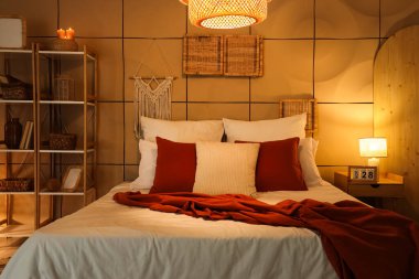 Karanlık yatak odasının içinde rahat bir yatak odası ve parlak lambalar var.