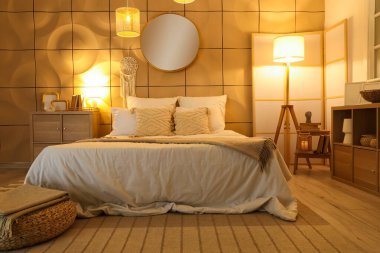 Karanlık yatak odasının içinde rahat bir yatak odası ve parlak lambalar var.