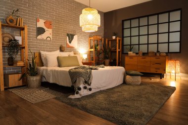 Yatak odası, raf üniteleri, çekmeceler ve parlayan lambalar.