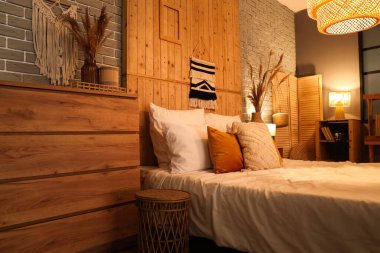 Yatak, çekmeceler, raf ünitesi, yatak odasının içinde parlayan lambalar.