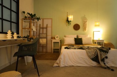 Çalışma odası, raf ünitesi ve yatak odasının içinde parlayan lambalar.