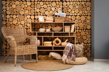 Hasır koltuklu rahat oturma odasının içi ve ahşap raflarda sonbahar süslemeleri.