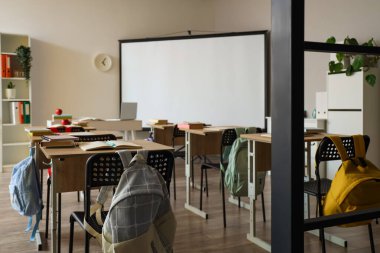 Okul sıraları ve projektör ekranlı sınıfın içi