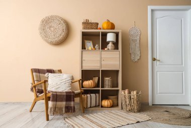 Koltuk ve raf, oturma odasının içindeki bej duvarın yanında.