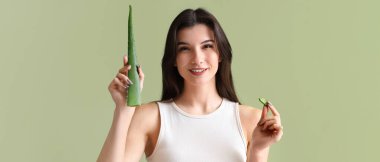 Yeşil arka planda aloe vera yaprağı olan güzel, genç ve mutlu bir kadın.