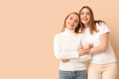 Bej arka planda annesine sarılan güzel bir genç kadın. Uluslararası Sarılma Günü