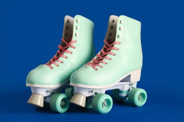 Mavi arka planda bir çift eski paten.