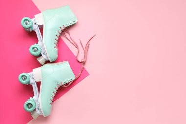 Pembe arka planda bir çift eski paten.